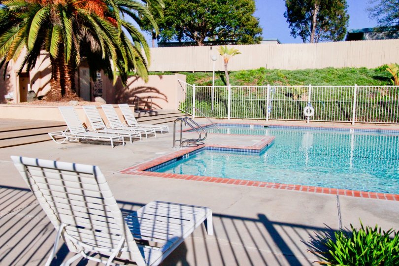 Fabulous swimming pool with chairs and trees around near villas in Westbluff Village of Costa Mesa