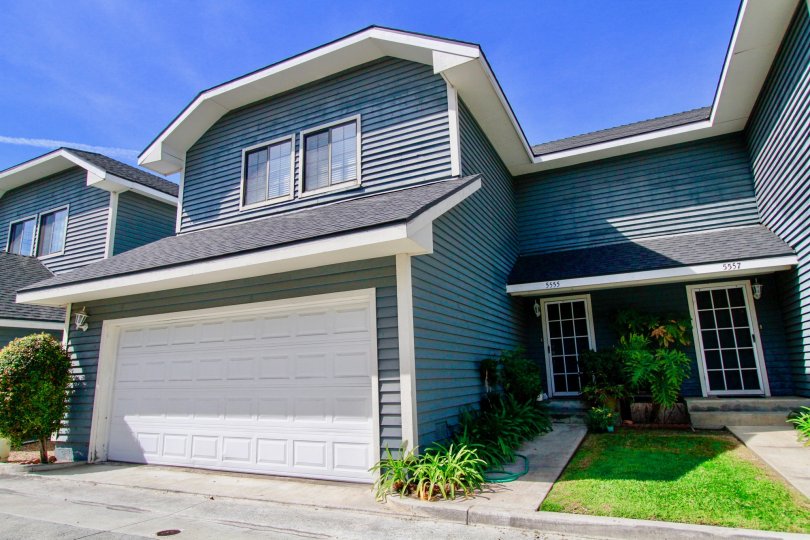 A HOUSE WITH CAR PARKING AND THE MAIN ENTRANCE ALSO NEAR TO THERE AND SMALL PLANTS ALSO NEAR TO THERE AT THE MORNING SUNSHINE TIME