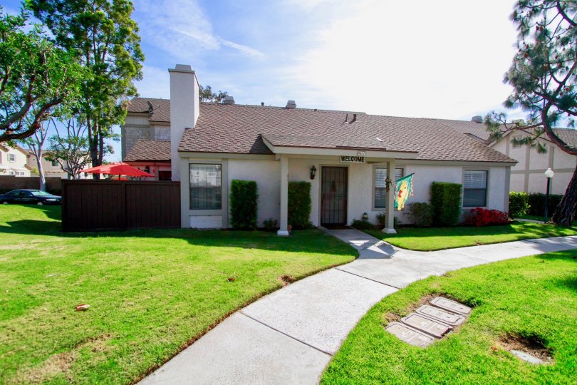A sunny day at the front door of a Influential Townhomes' house with a well-cared grass front yard