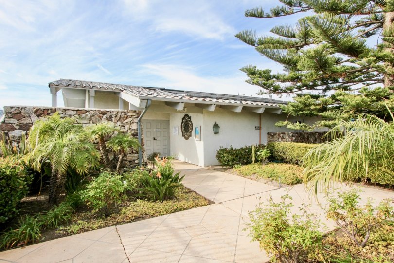 a sunny day in the dana bluffs with house that has stone walls and garden of trees