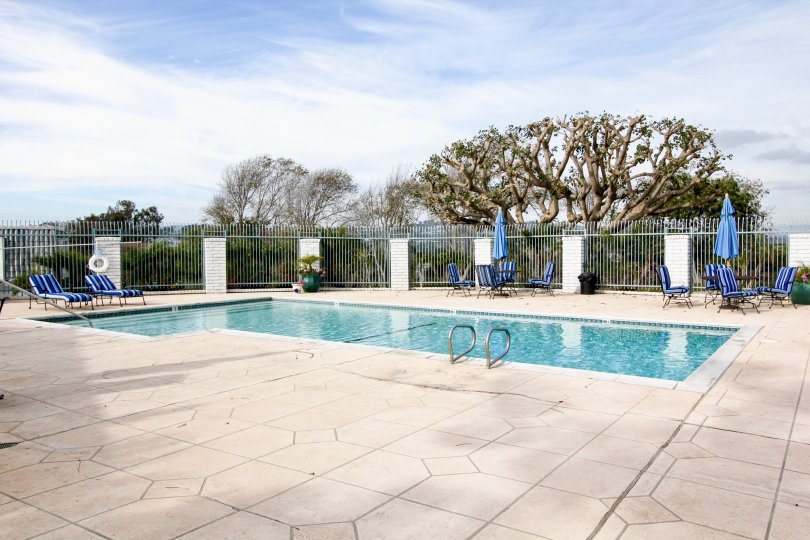 a sunny day in the dana bluffs with a swiming pool that has clear blue water andsteel compound around