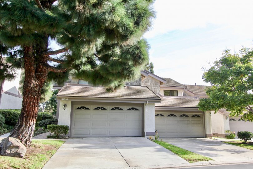 Front garage doors and open space with trees of Old Mill Pond community, Dana Point, CA