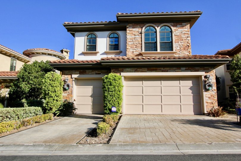a sunny day in the pointe monarch with house that has stone walls and 2 doors