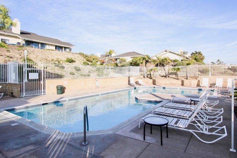 Long Swimming Pool with Chairs and dustbin placed in Sea Ridge