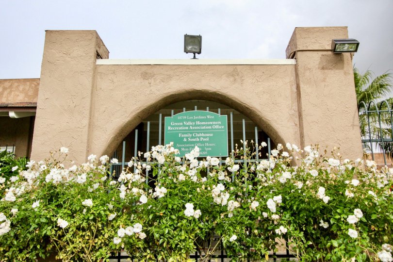 White flowers in front of the gate at Green Valley Townhomes Fountain Valley, CA