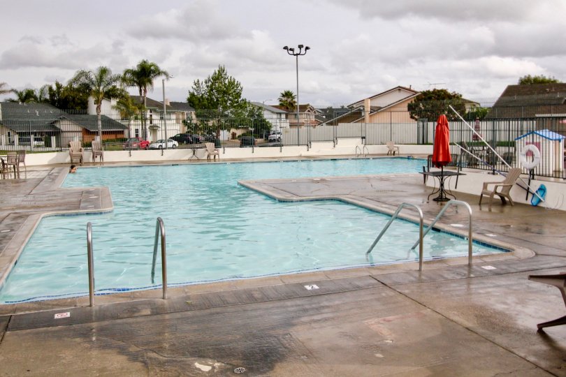 Near the swimming pool, umbrella is closed at dinning table in Green Valley Townhomes