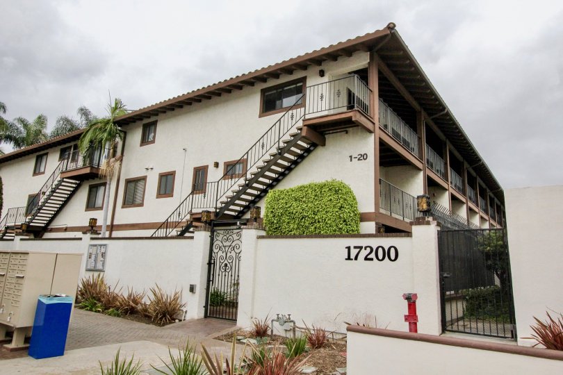 A large triple story housing building with two sets of stairs at Los Caballeros in Fountain Valley CA