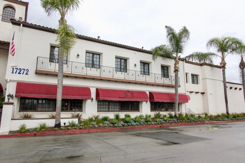 A building with maroon onning with large windows in Los Caballeros community.