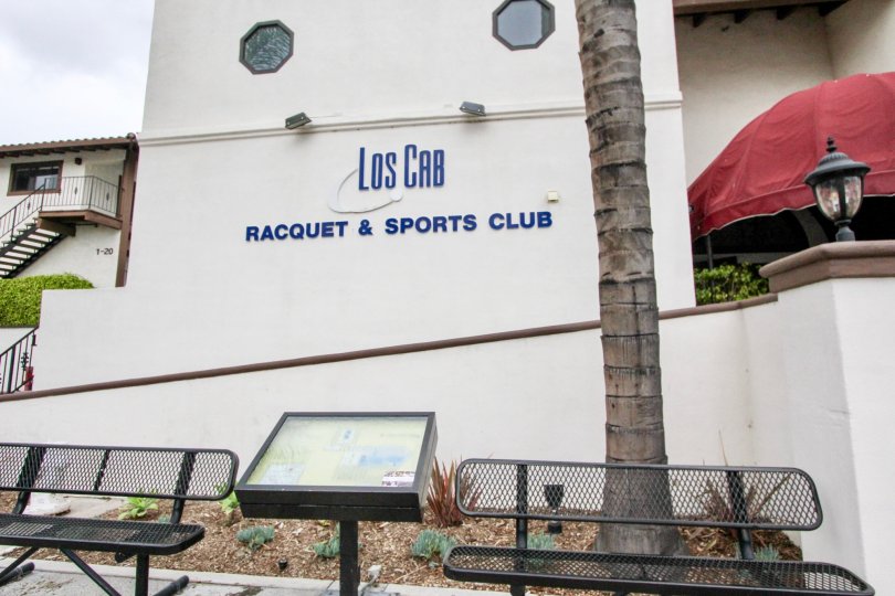 Los Cab Racquet & Sports Club sign in the color blue and background cream located in Los Caballeros community.