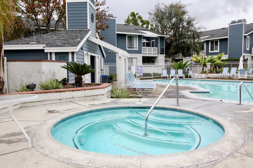 There are two swimming pools near New chase Villa's with seating chairs and trees