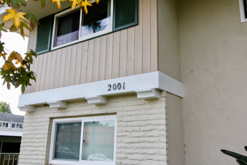 Two floor apartment with room number and trees also located at the front