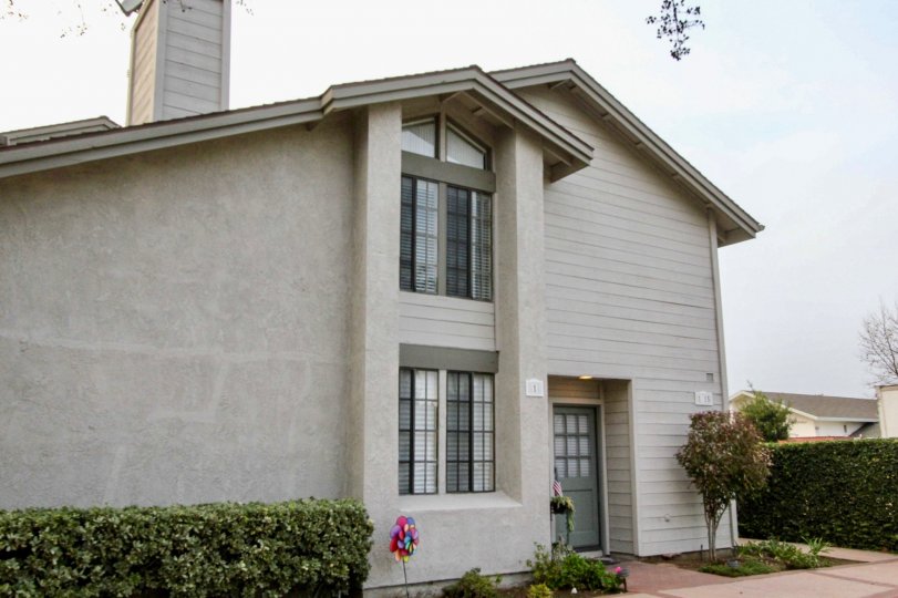 A home in the Chapman Villas community with a walkway and trimmed bushes.