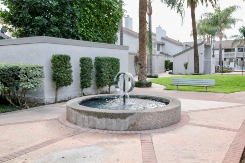 In pathway, Fountain with water and bench are fixed at center in Chapman Villas