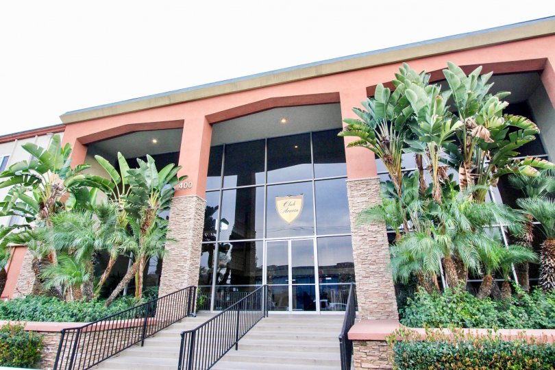 A large building with alote of window area and trees at club acacia community in fullerton, california.