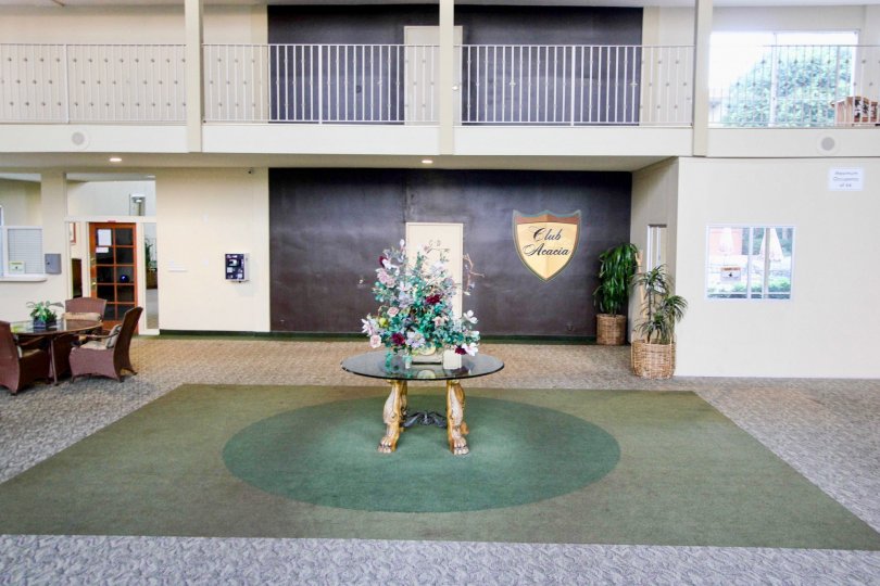 A lobby in a Club Acacia building with flowers on top of a table.