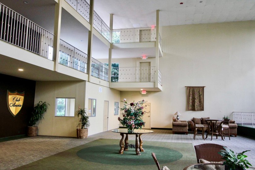 Club Acacia Fullerton California the room contains artful sofa and standing tables, plants