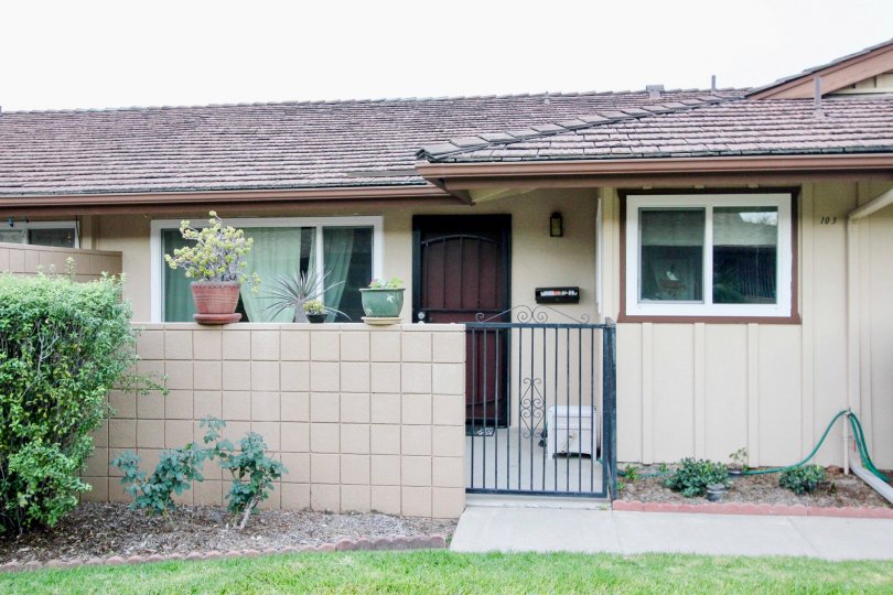 A single story home with a black iron gate near it's front door at coco Palms in Fullerton CA