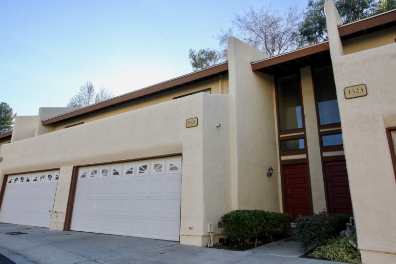A apartment building in Country Villas with two garages on a sunny day.