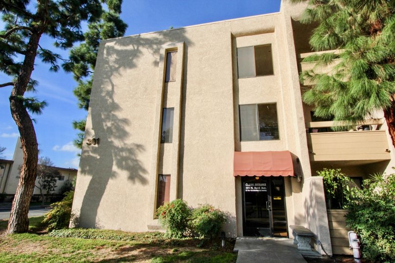 A apartment building in Fullerton Fountains with a door and walkway on a sunny day.