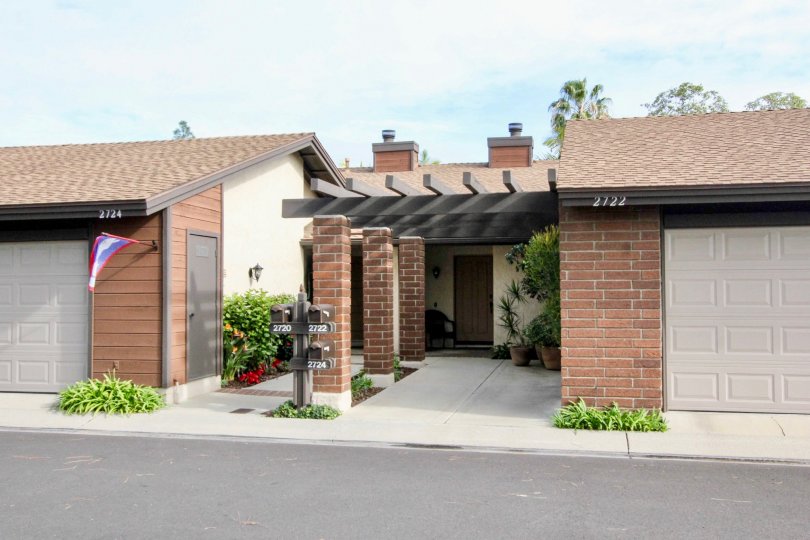 A homes in Fullerton Pines with garages and flags on a sunny day.
