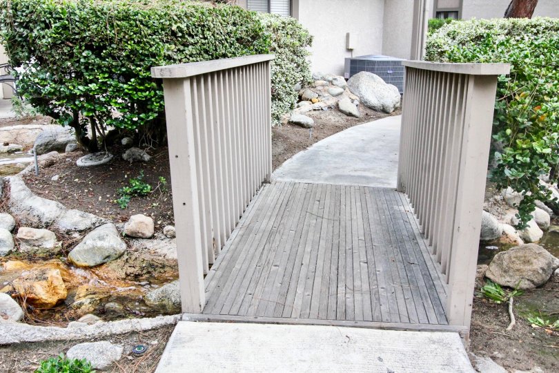 A bridge in the Hidden Lakes community with a stream below it.