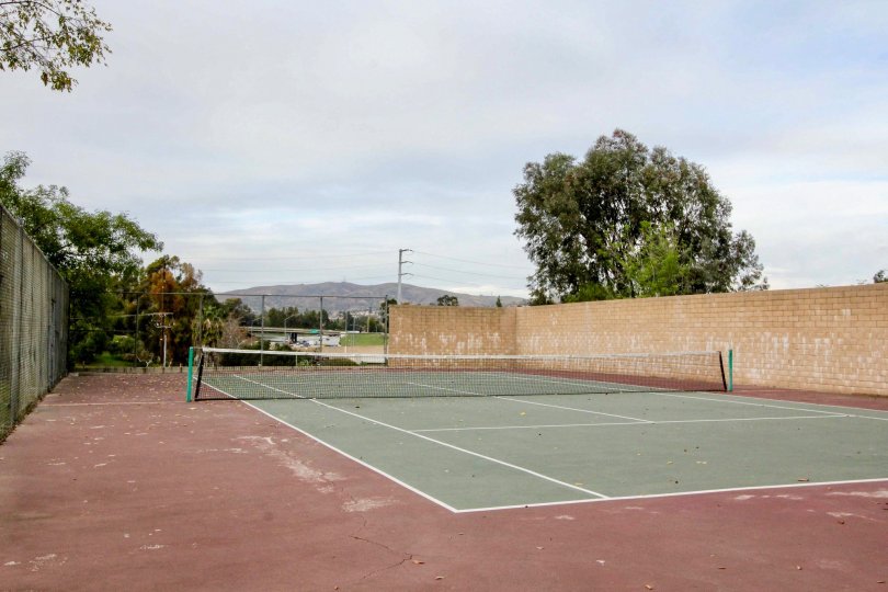 Tennis court in Parking Ridge with a net and fence on a cloudy day.