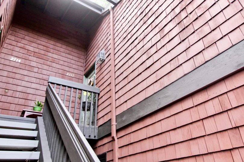 Staircase to a Quail Ridge apartment with red shingle sidlng.