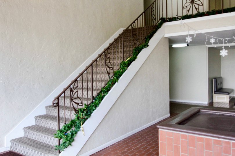 Shadow LAne staircase with Christmas garland and brick floor.