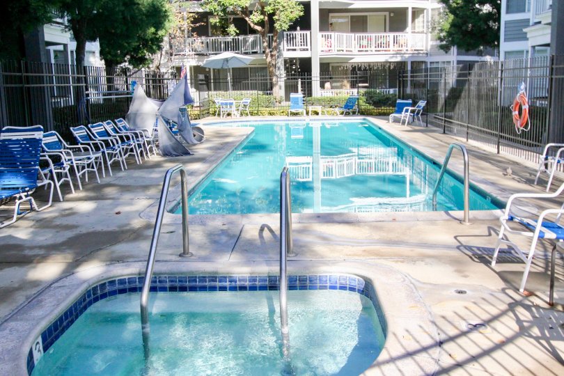 THE TREES IN THE GREENBRIER TERRACES WITH THE SWIMMING POOL, CHAIRS, BALCONIS