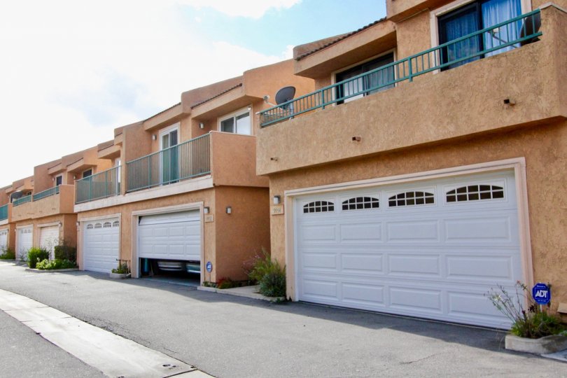A row of brown condos with garages near a driveway at Park Villas II in Garden Grove CA