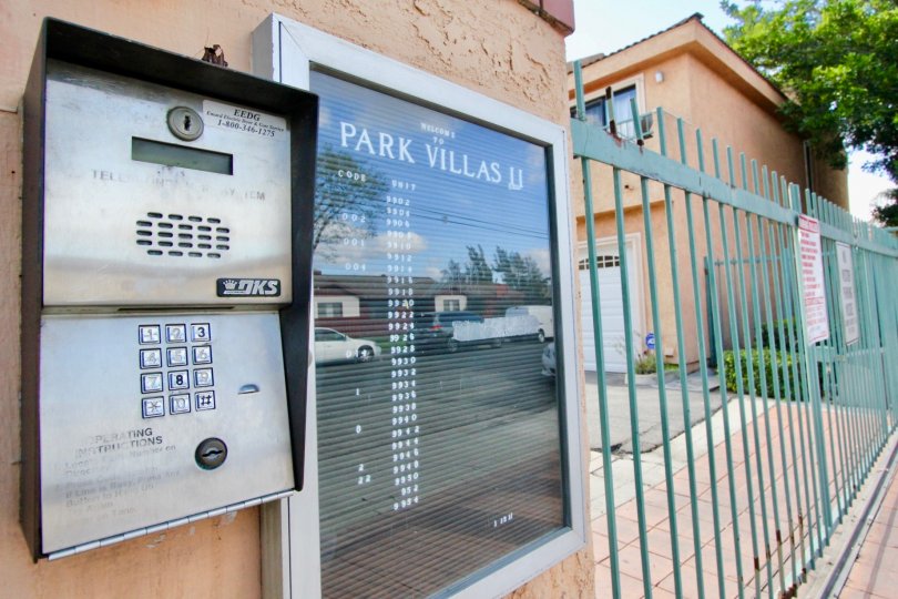 THE BUILDING IN THE PARK VILLAS II WITH THE ELECTRONIC MACHINE, GATE, PLANTS