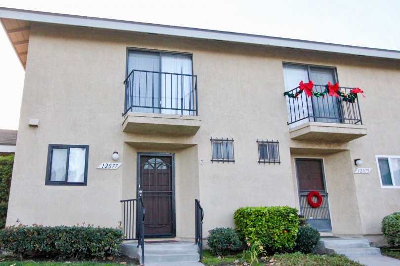 residencies with second floor balconies with one of them decorated for christmas