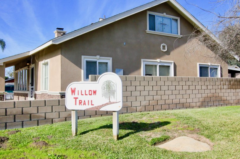 THIS IMAGE VIEWS THE HOUSE WITH THE GROUND WHICH HAS THE NAME BOARD AND PLANTED TREES AND BEAUTIFUL LAWN IS IN THE CITY OF GARDEN GROVE