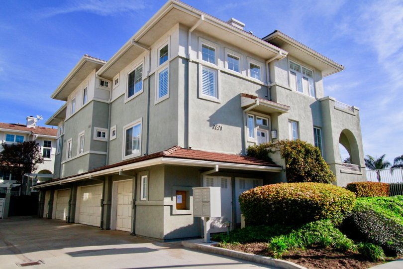 Pacific Park Villas apartment building with bushes and other plants in front.