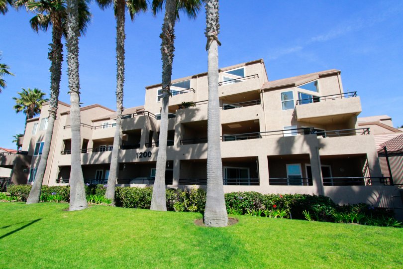Pierhouse apartment building with trees and bushes on a sunny day.