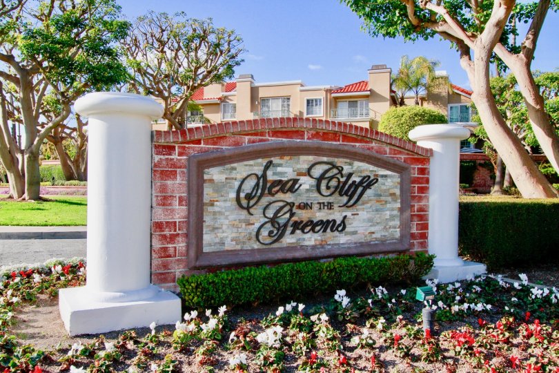 Seacliff on the Greens sign with flowers and bushes on a sunny day.