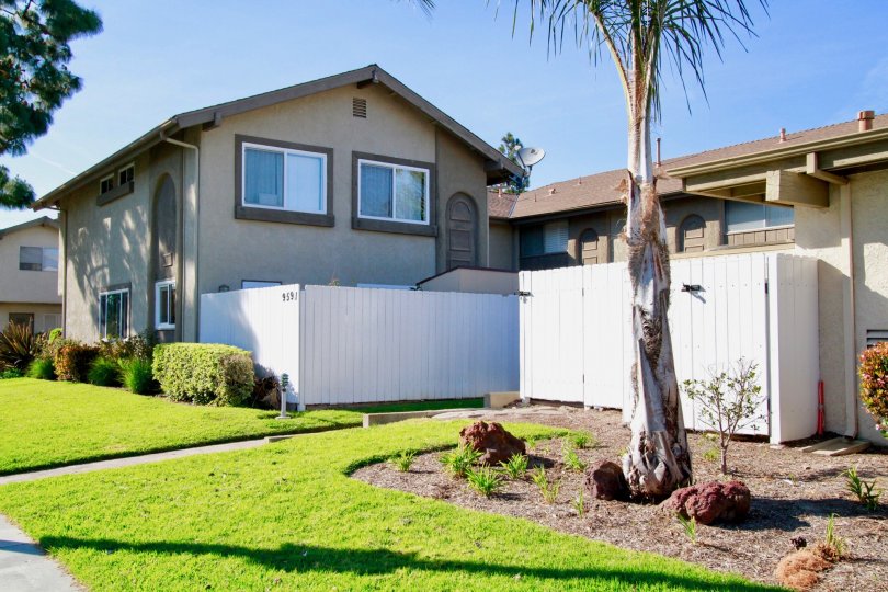 THE HOUSE WITH DOOR CLOSED AND WINDOWS CLOSED AND A TREES ALSO AVAILABLE AND THE GRASS AND PLANTS ALSO AVAILABLE IN FRONT OF THE PLACE.