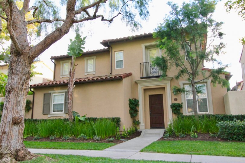 THE HOUSE WHICH IS IN THE CITY OF IRVINE THAT SHOWS LOT OF PLANTS, LAWN AND THE TREES