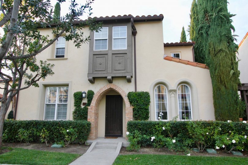 THE FRONT VIEW OF THE HOUSE WITH PLANTS, TREES, GLASS WINDOWS ARE SITUATED IN THE CITY OF IRVINE