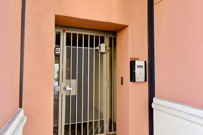 Silver security door at pink entry way at Avenue One in Irvine CA