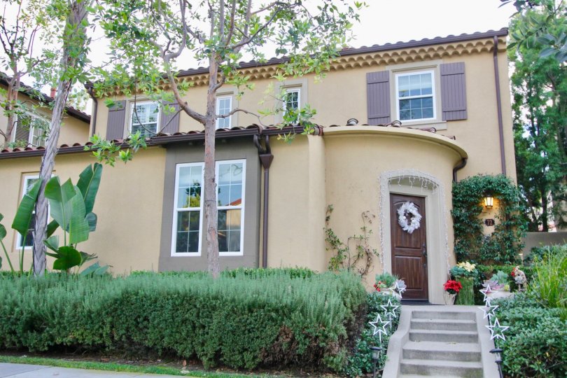 THE ENTRANCE WAY TO THE HOME WHICH SHOWS THE PLANTS, TREES, GLASS WINDOWS, STEPS, LAMP LIGHTS ARE THERE IN THE IRVINE CITY