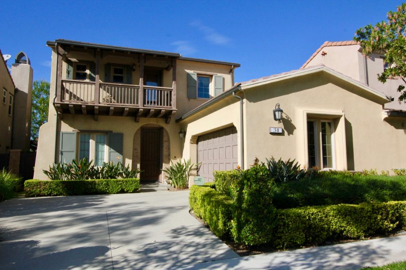 THE FRONT VIEW OF VILLA WITH THE MANY PLANTS WHICH IS IN LOS ARBOLES COMMUNITY
