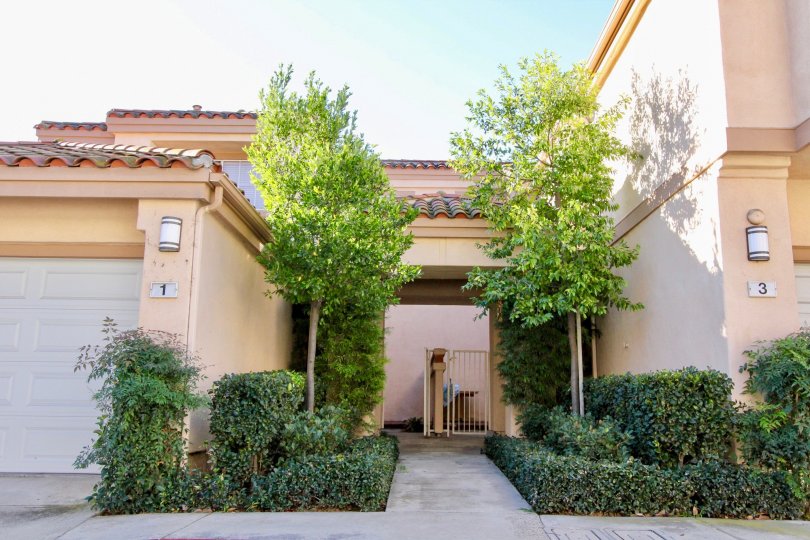 A sidewalk surrounded by trees and plants inside Norhtwood Villas in Irvine CA