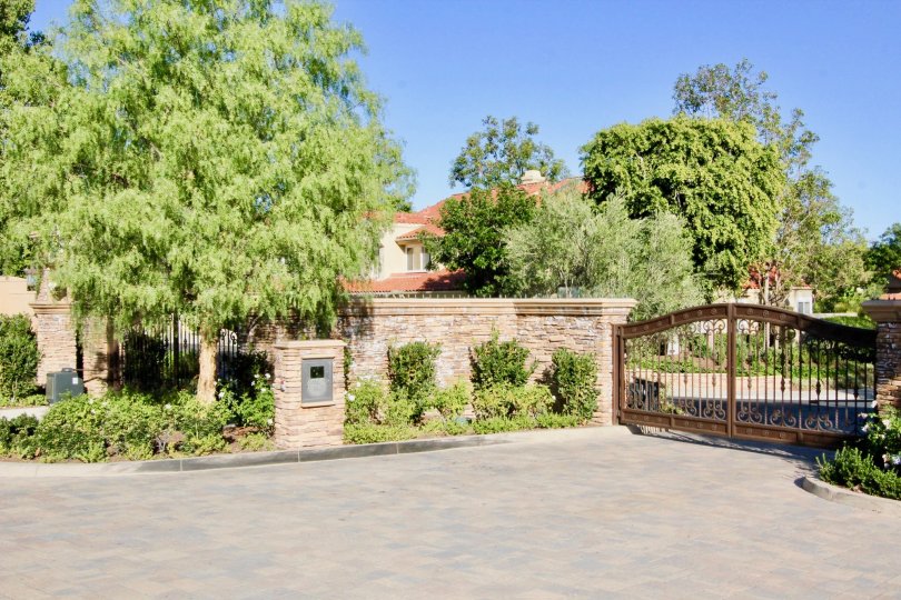 gate driveway tree garden western west coast sun outdoors upperclass fancy stone fence metal