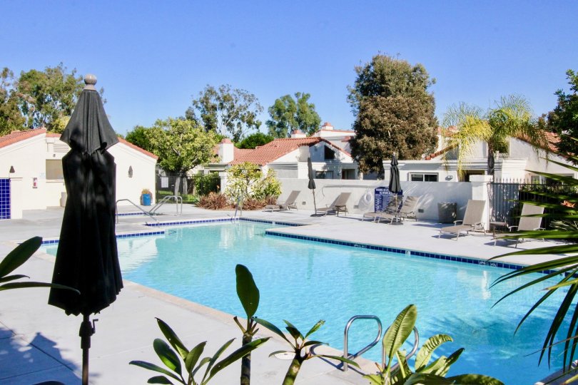 A pool in the Villas at RSJ community surrounded by white houses.