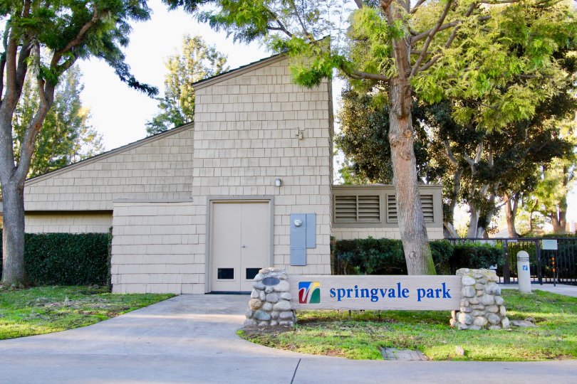 A street view of a sign and common area building and trees at Woodbridge Crossing