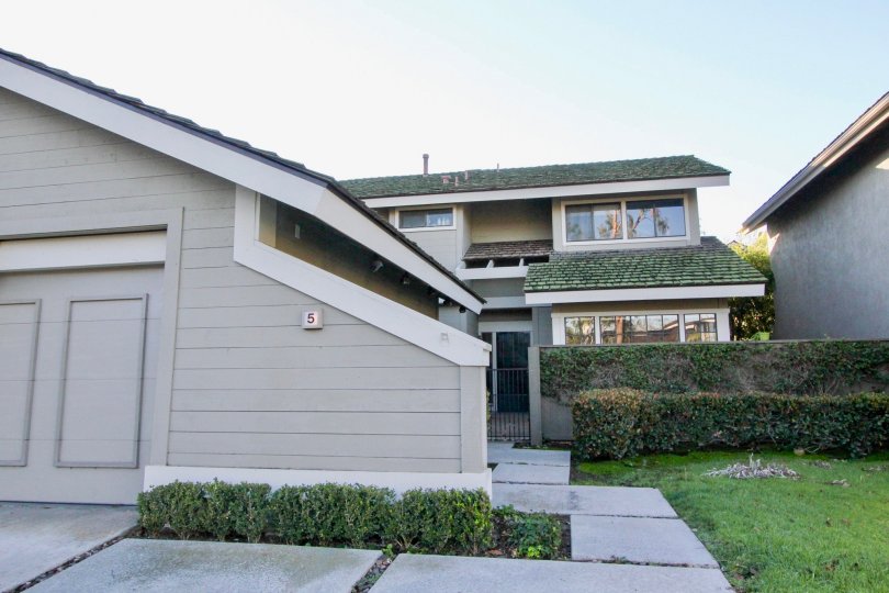 A house with grey walls and green sloped roofs inside Woodbridge crossing community