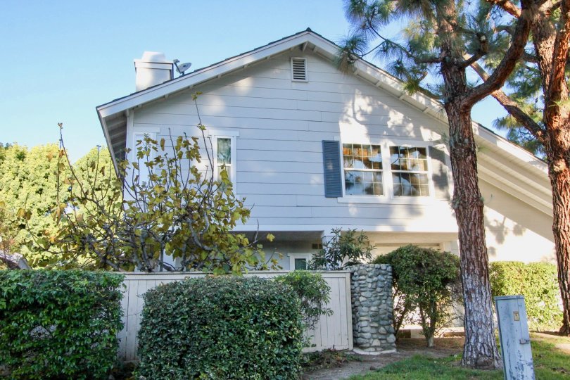 A sunny day in the Woodbridge Estates with green shrubs around the home.