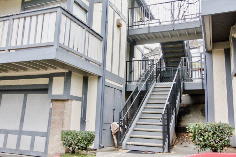 A set of gray stairs with black hand rails inside Heritage Walnut in La Habra CA
