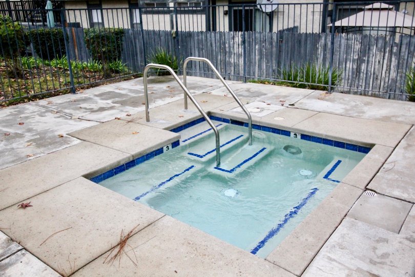 A small swimming pool in the Heritage Walnut covers with some iron grill and some shrubs.